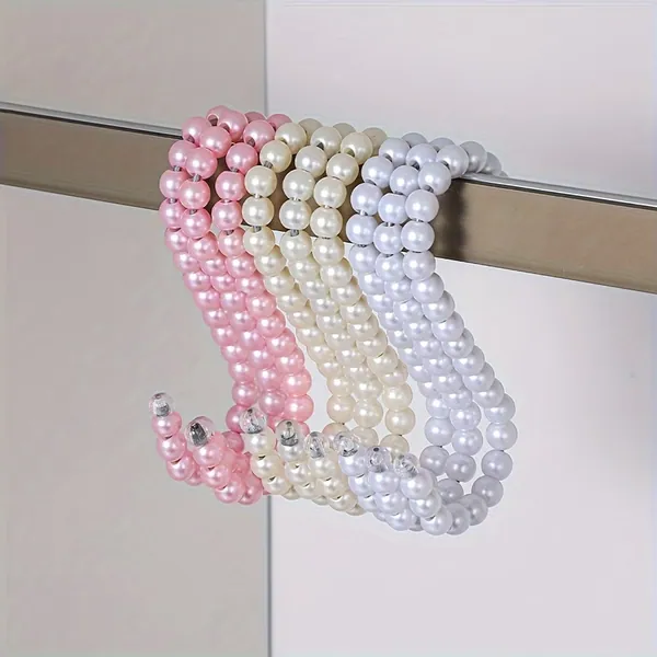 Handmade pearl beaded hangers in pink, ivory and pearl white on a wardrobe rail